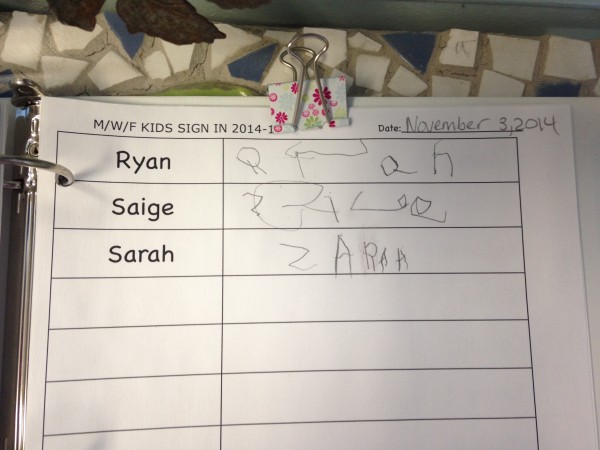 Sarah's writes her name at check in